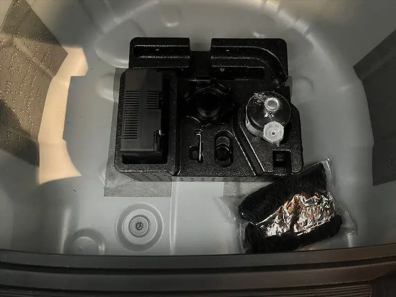 Coffre ouvert d'une SEAT IBIZA blanc Nevada, montrant le rangement sous le plancher avec kit de réparation pneus.