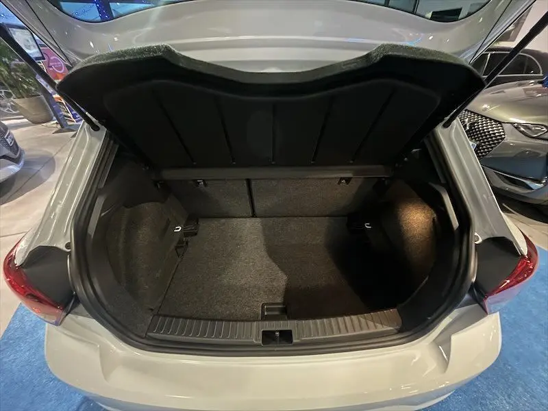 Coffre ouvert vu de l'arrière d'une SEAT IBIZA blanc Nevada métal 2024, montrant un espace de chargement vide et propre.