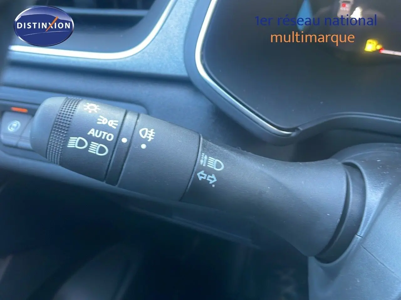 Gros plan sur la commande des phares et clignotants du Renault Captur E-Tech hybride, intérieur noir.