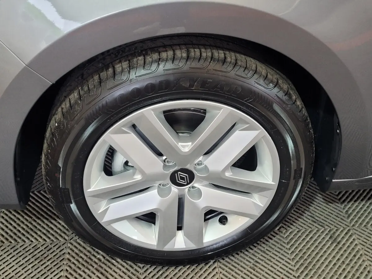 Gros plan sur la roue avant droite d’une Renault Clio gris foncé, jante alliage à cinq branches doubles.