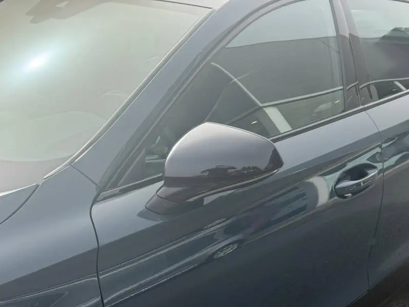 Vue rapprochée du rétroviseur côté gauche d’un CUPRA Formentor bleu Fjord avec poignée de porte assortie.