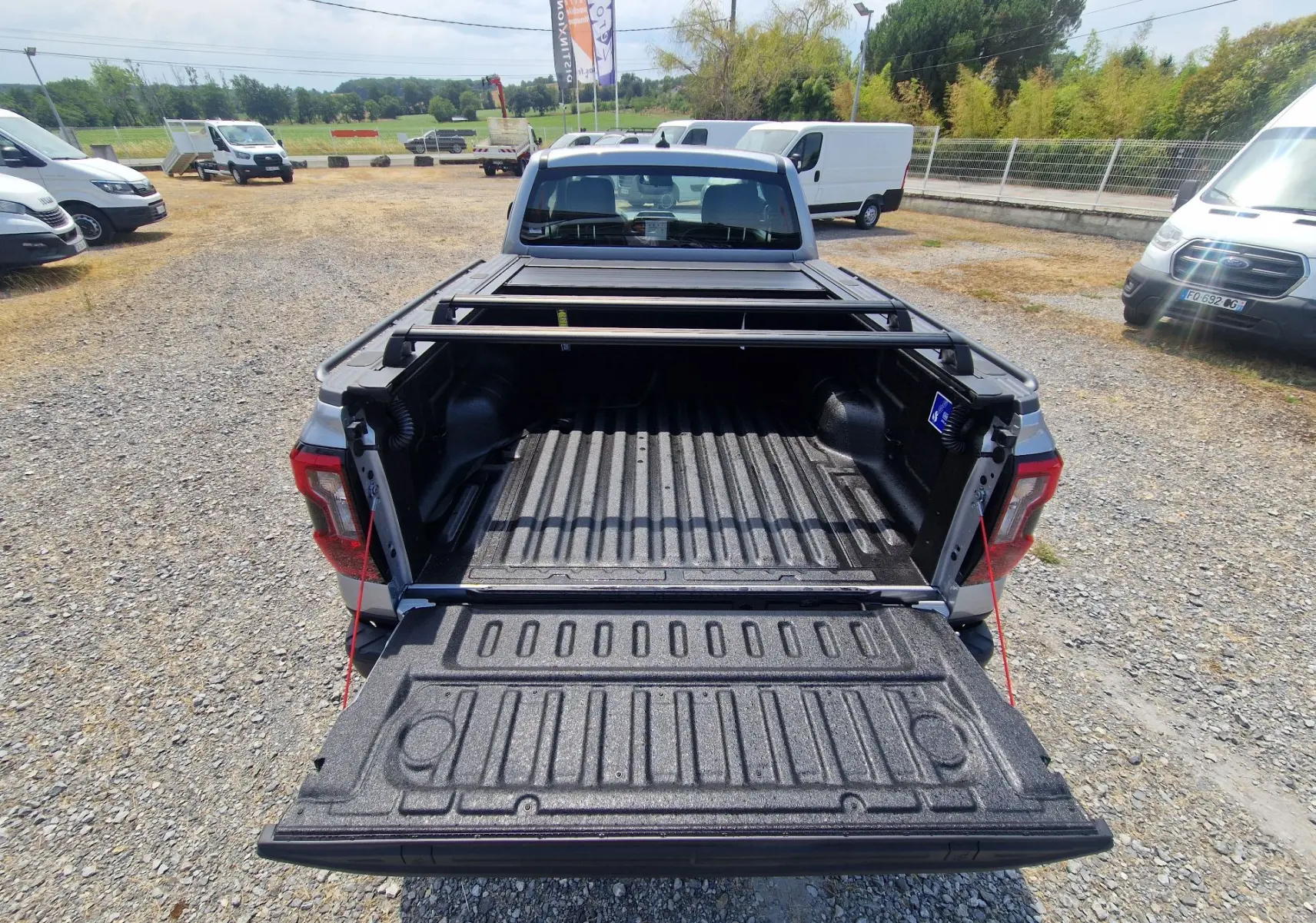 Vue arrière du Ford Ranger Super Cabine gris Iconic avec plateau ouvert et barres de protection visibles.