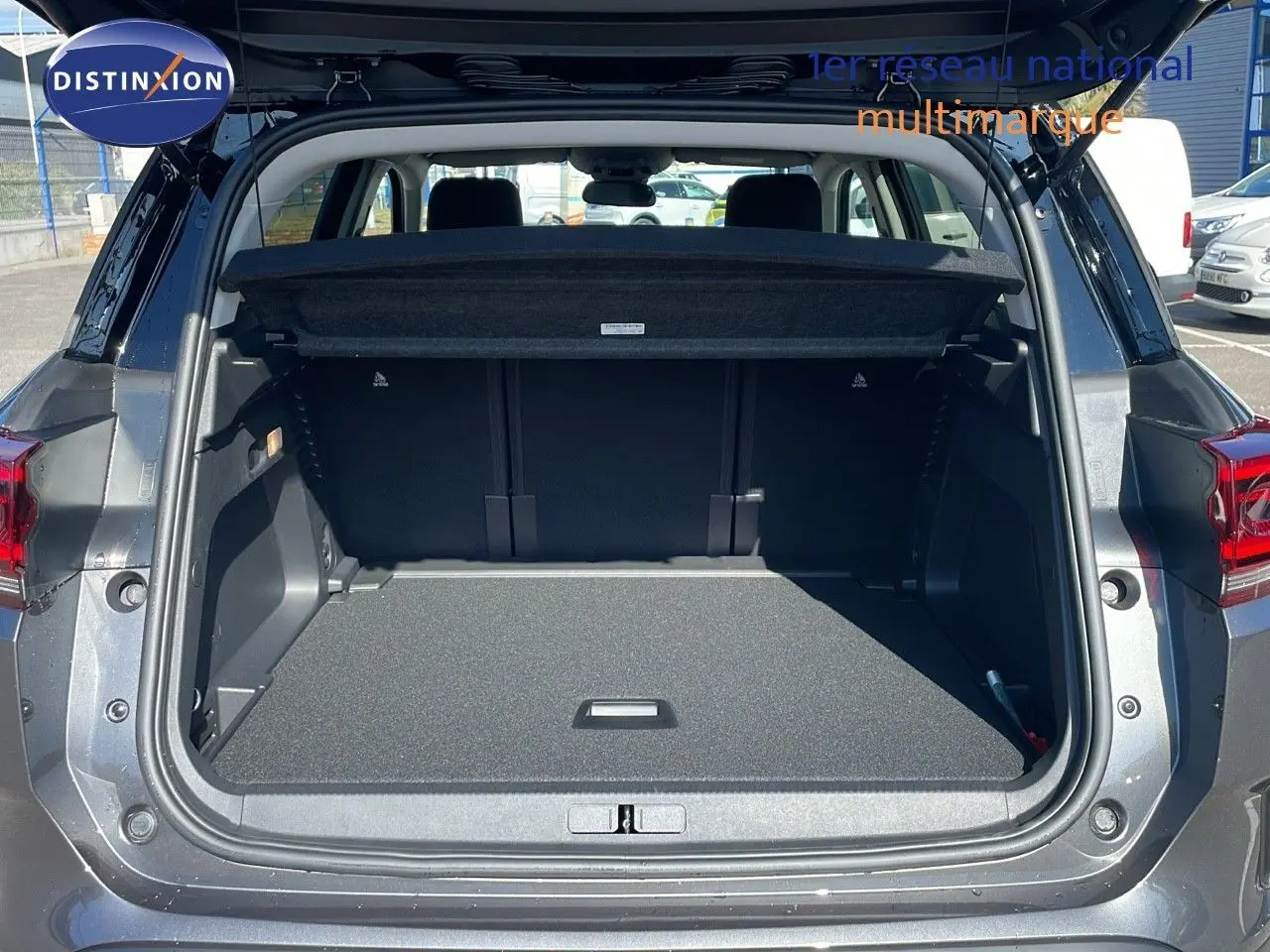 Coffre ouvert d'un Citroën C5 Aircross gris platinium métal avec toit noir, vue arrière intérieure dégagée.