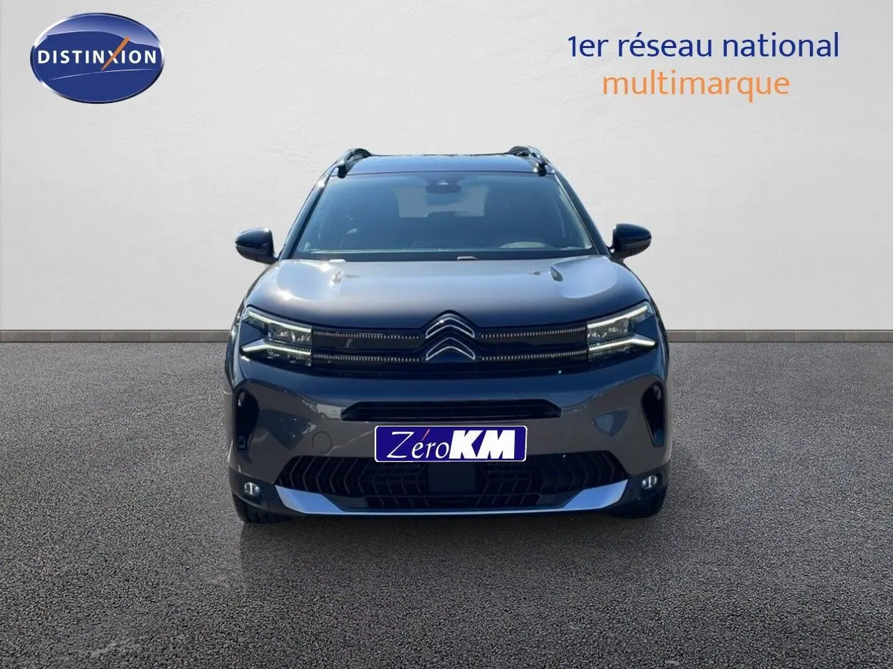 Vue frontale d'un Citroën C5 Aircross 2025 gris platinium métal avec toit noir et signature lumineuse LED distinctive.