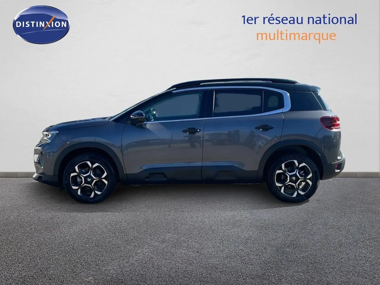 Profil droit d'un Citroën C5 Aircross 2025 gris platinium avec toit noir, roues alliage bicolores et vitres teintées.