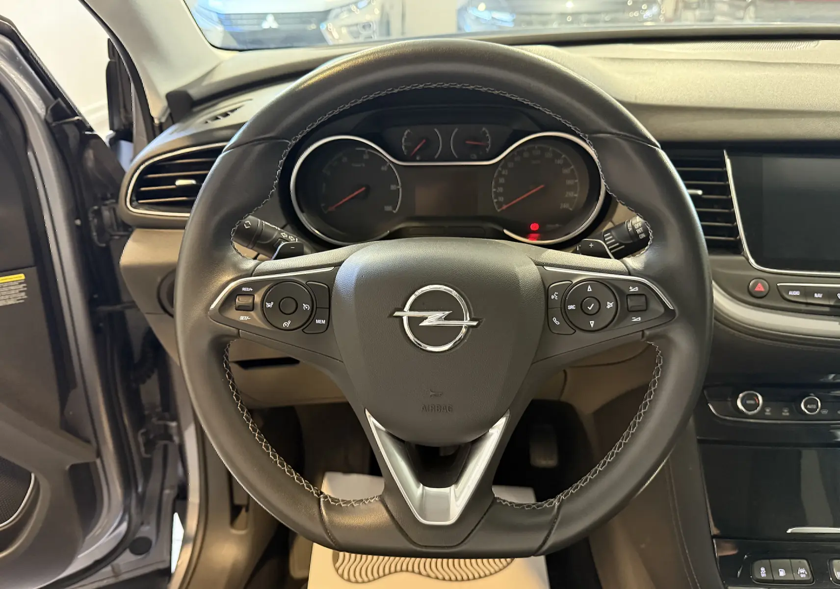 Vue rapprochée du volant en cuir noir de l'Opel Grandland X 1.6 Hybrid Turbo 2021 avec tableau de bord et écran tactile.