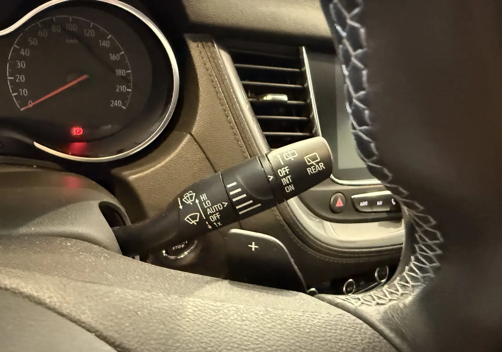 Gros plan sur la manette d’essuie-glace à gauche du volant du tableau de bord du Grandland X gris Himalaya.