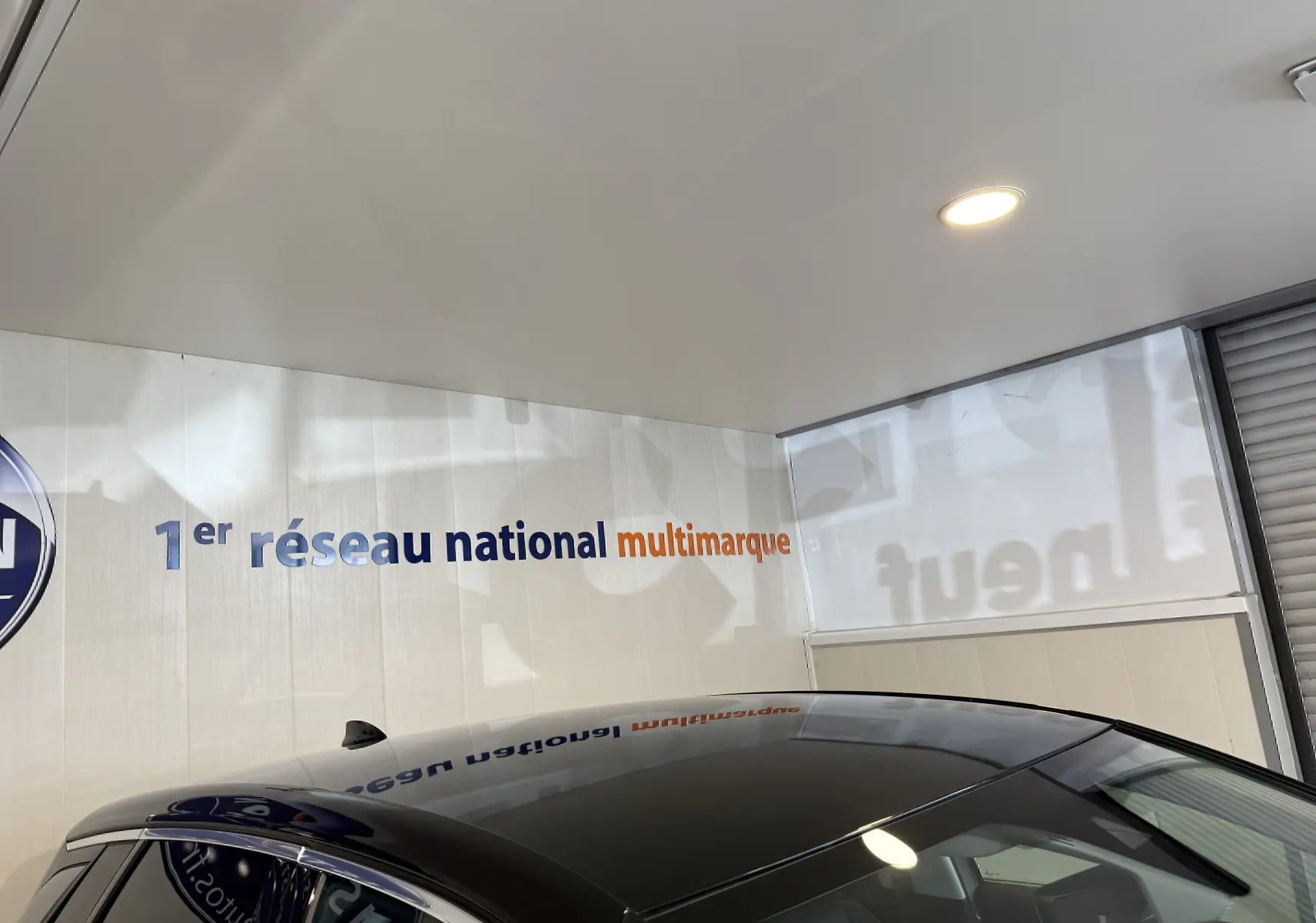 Toit noir brillant de l'Opel Grandland X gris Himalaya, vue partielle en intérieur sous éclairage artificiel.