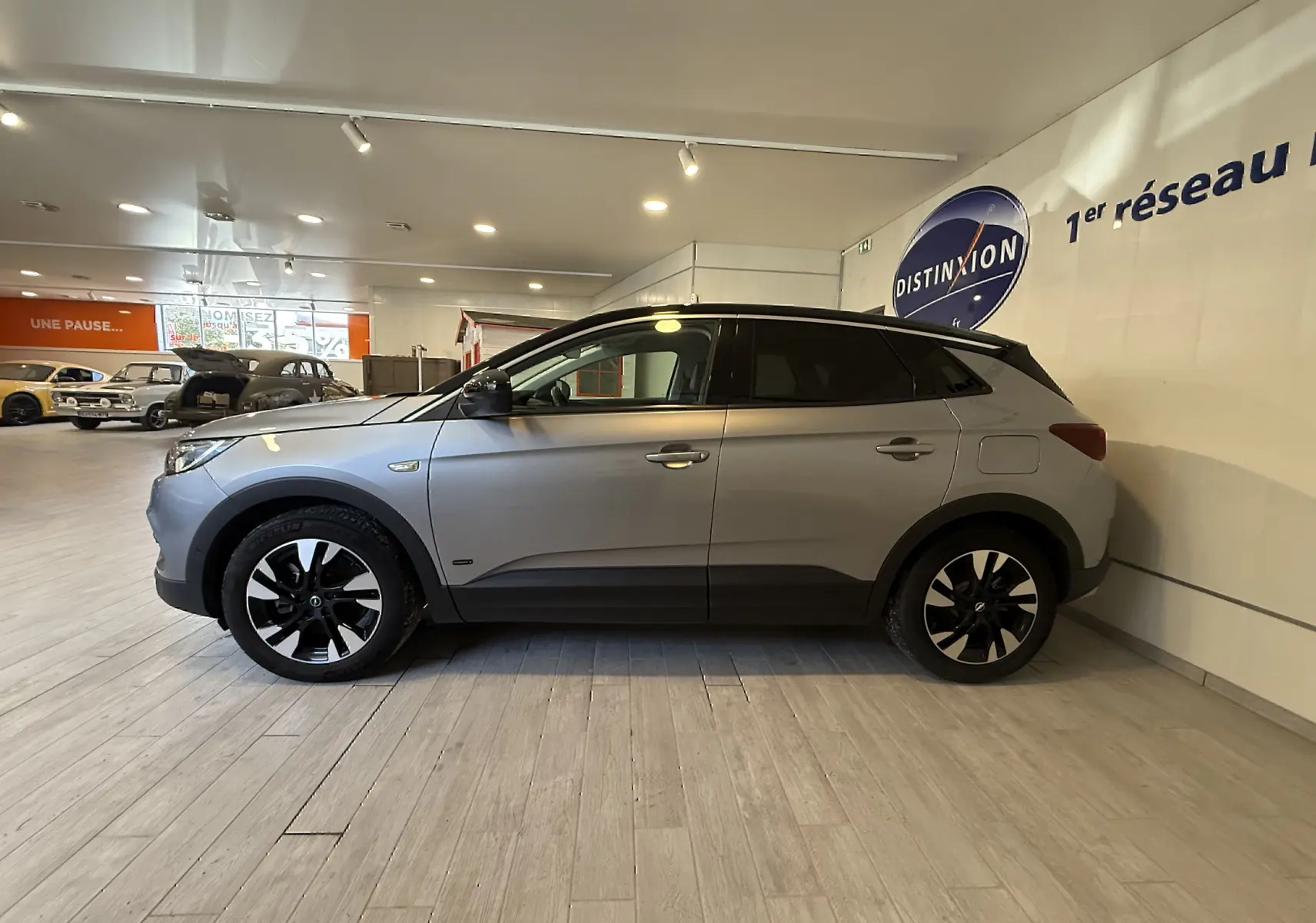 Opel Grandland X gris Himalaya en profil droit, SUV hybride rechargeable avec jantes noires et toit noir contrasté.