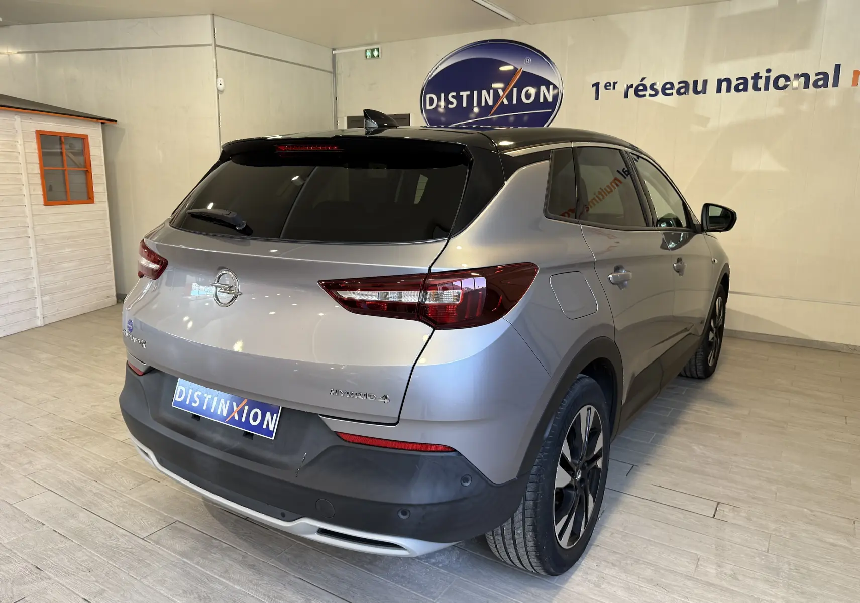 Vue 3/4 arrière droite d'un Opel Grandland X gris Himalaya hybride rechargeable avec toit noir et jantes noires.