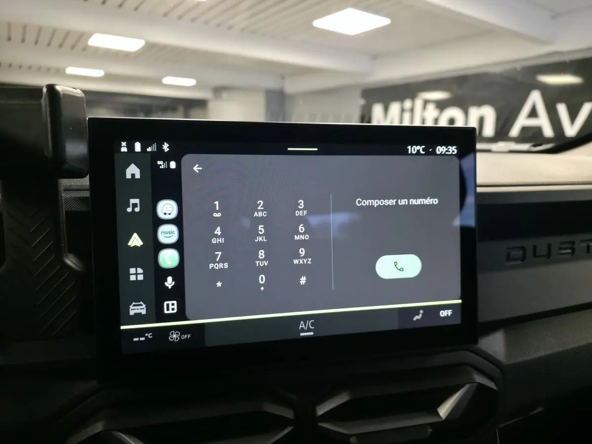 Écran tactile central affichant le clavier téléphonique dans l’habitacle du Dacia Duster noir, vue de face.