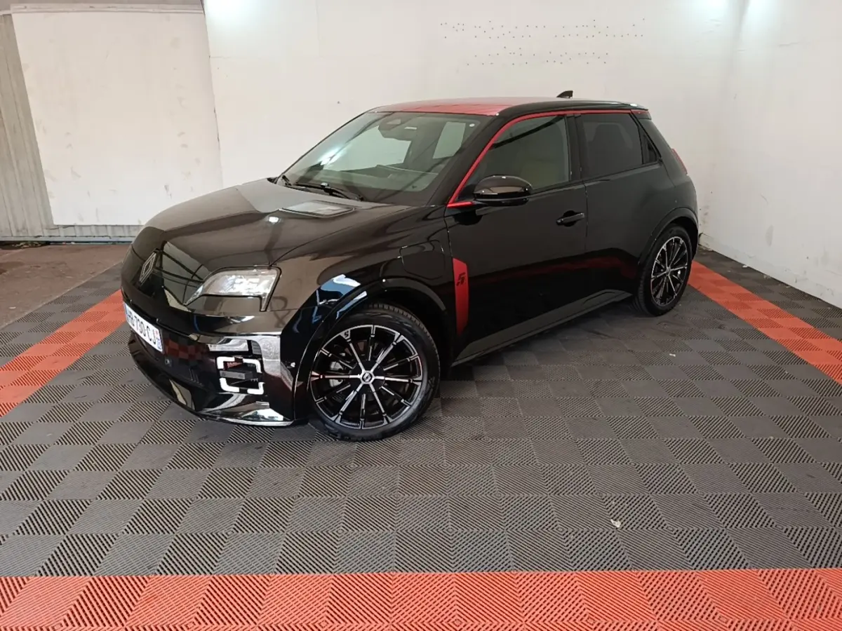 Renault R5 Iconic 2024 vue 3/4 avant côté gauche, carrosserie noire avec toit et détails rouges, jantes noires stylées.