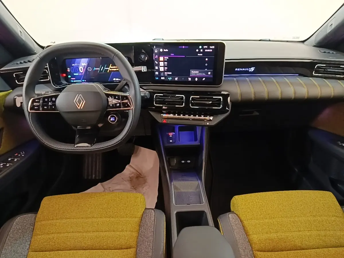 Vue intérieure avant de la Renault R5 Iconic 2024 avec tableau de bord numérique et sièges jaunes texturés.