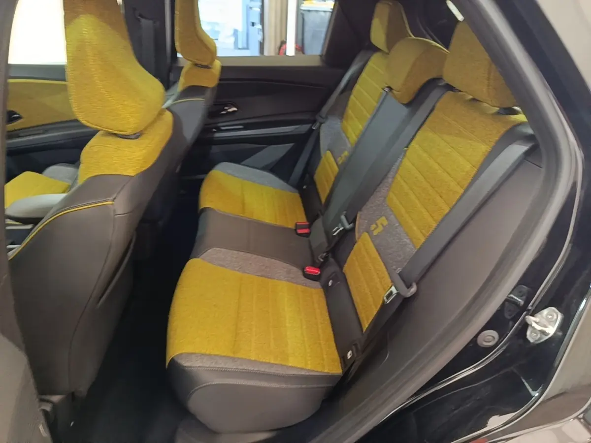 Vue intérieure côté droit montrant les sièges arrière jaunes et gris du Renault R5 Iconic Cinq 2024 électrique.