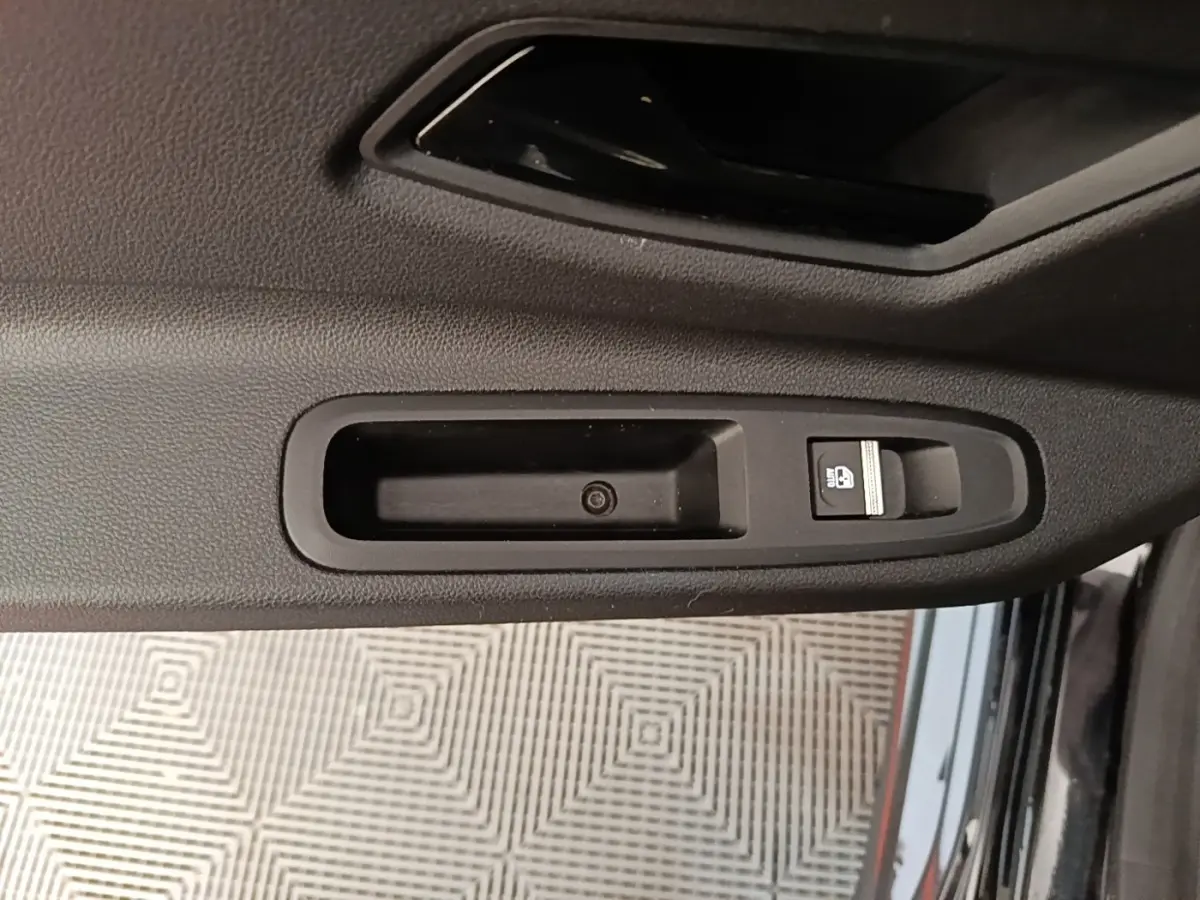 Gros plan sur la commande de verrouillage de porte noire côté intérieur d'une Renault R5 Iconic 2024.