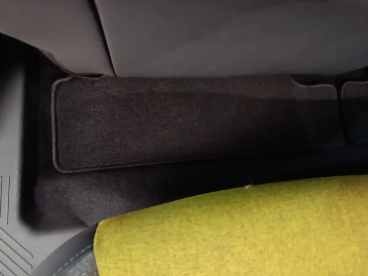 Détail de la moquette noire et de l'assise verte à l'arrière de la Renault R5 Iconic Cinq 2024 électrique.