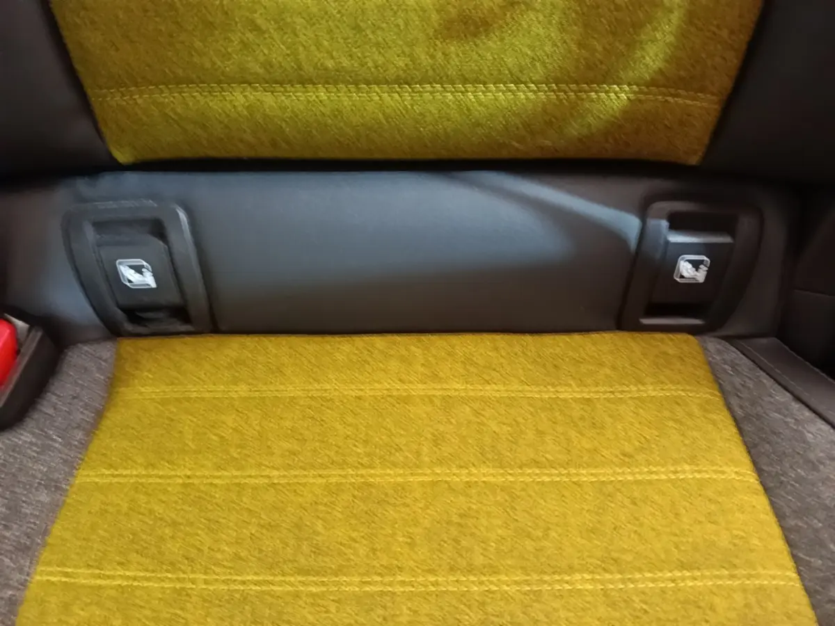 Gros plan sur la banquette arrière jaune moutarde de la Renault R5 Iconic Cinq 2024 avec attaches Isofix visibles.