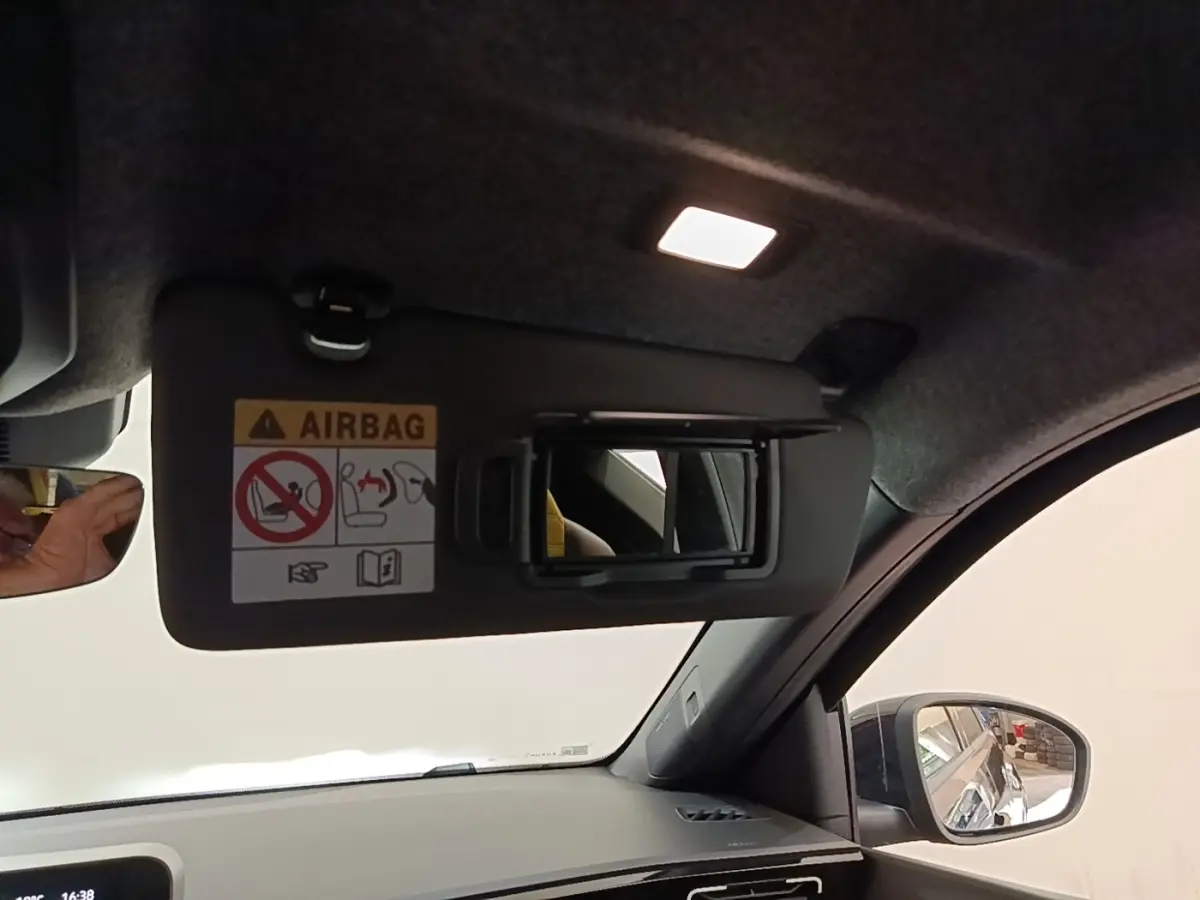 Intérieur de la Renault R5 électrique 2024, vue côté droit sur pare-soleil avec miroir et tableau de bord gris.