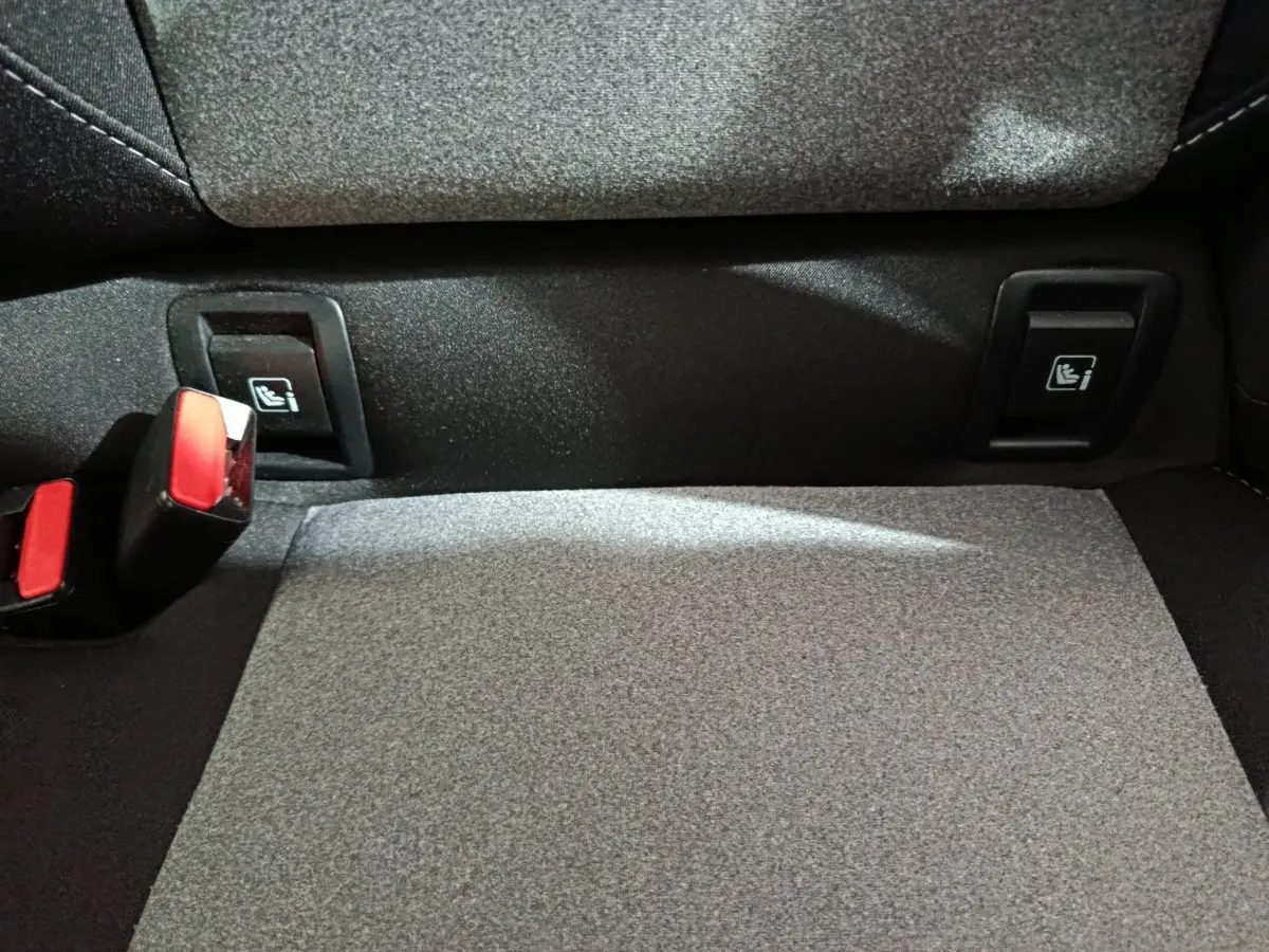 Détail de la banquette arrière grise de la Renault Clio Evolution Blue dCi 100 avec fixations Isofix et boucles de ceinture rouges.