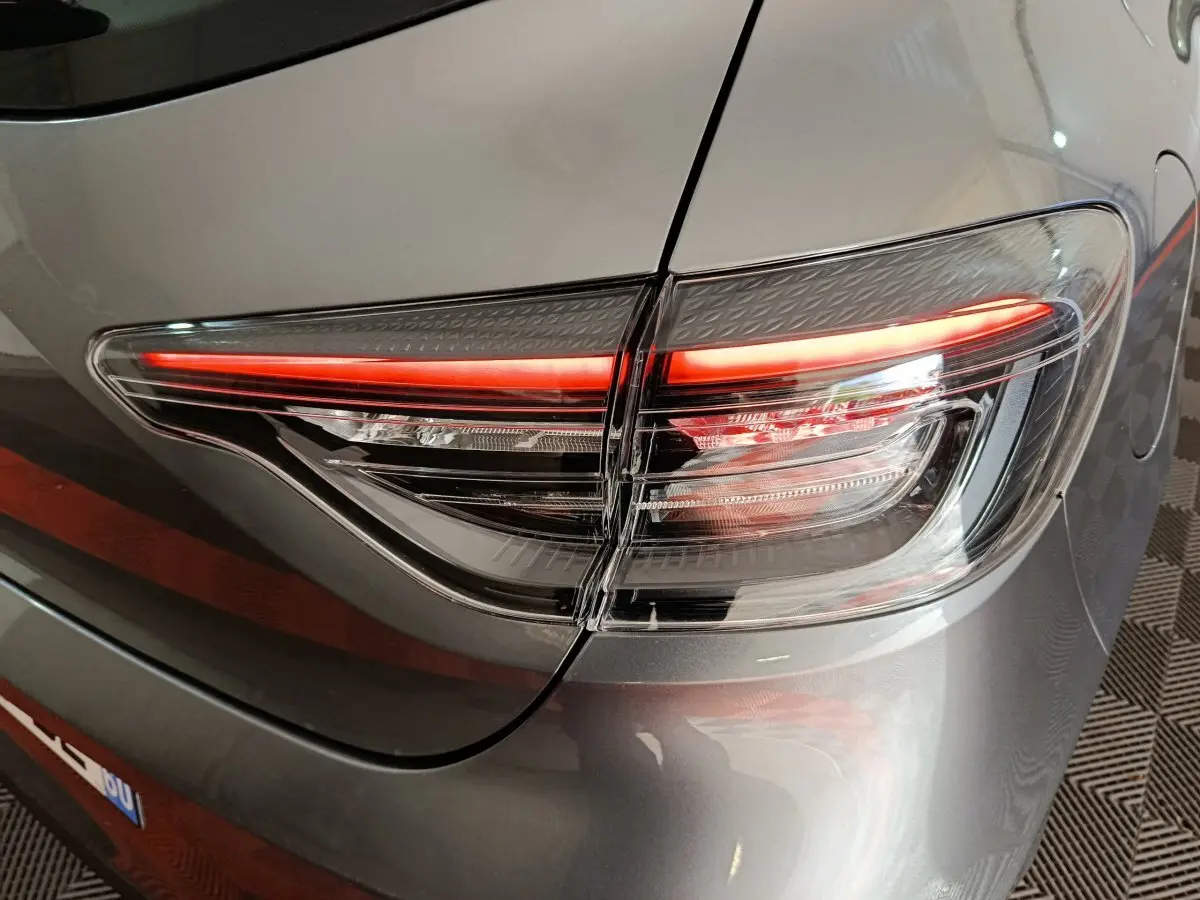 Gros plan sur le feu arrière droit allumé d’une Renault Clio gris clair Evolution Blue dCi 100 2025.