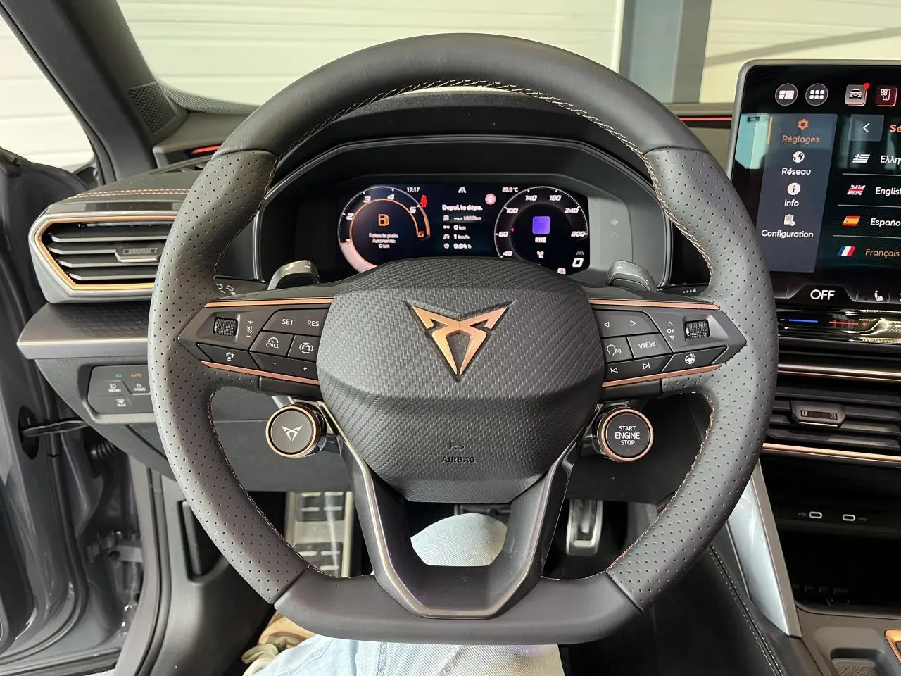 Vue intérieure centrée sur le volant perforé noir avec logo cuivre du CUPRA Formentor gris clair 2025.