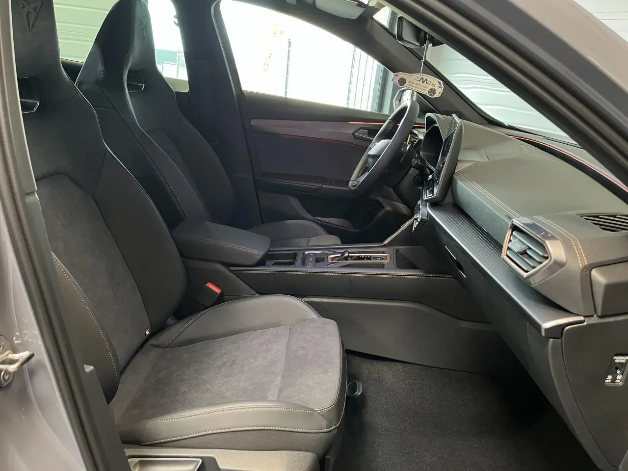 Vue intérieure côté conducteur du CUPRA Formentor 2025 gris clair, avec sièges sport noirs et tableau de bord moderne.