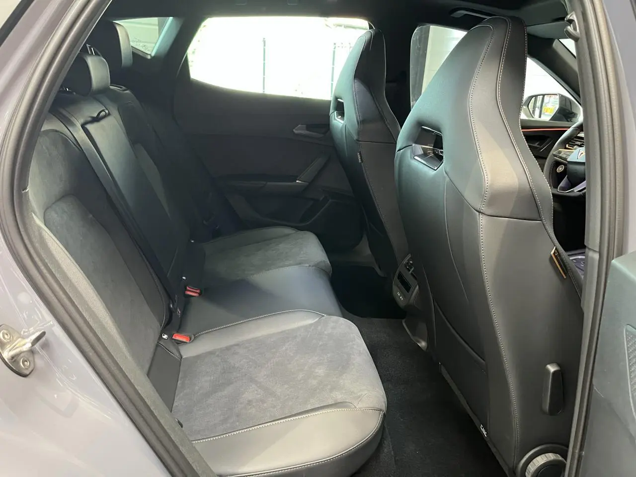 Vue intérieure côté gauche des sièges arrière gris clair et noir du CUPRA Formentor 2025 avec finitions en cuir et alcantara.