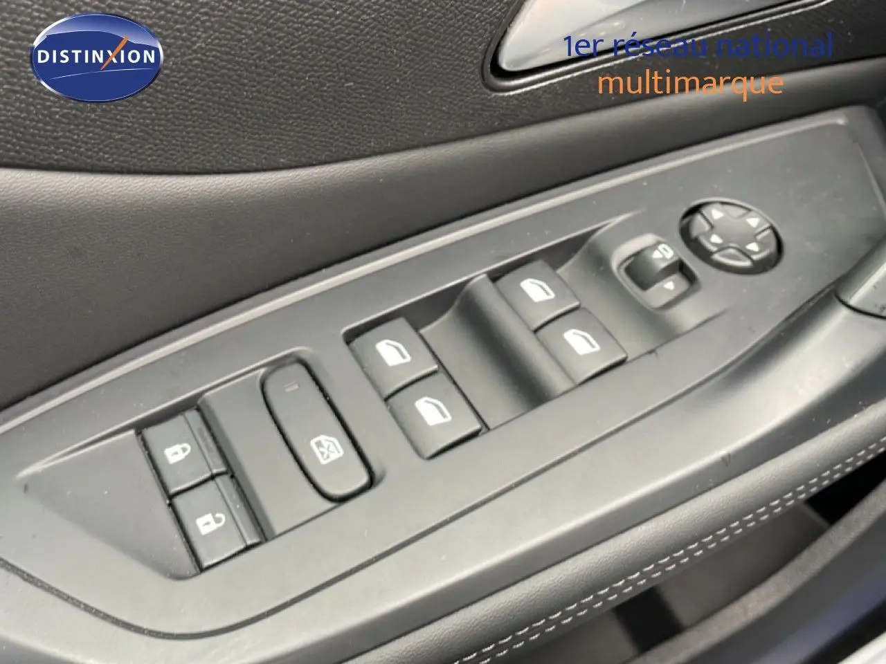 Gros plan sur les commandes des vitres et rétroviseurs côté conducteur d'une Peugeot 408 1.2 Hybrid gris Selenium.