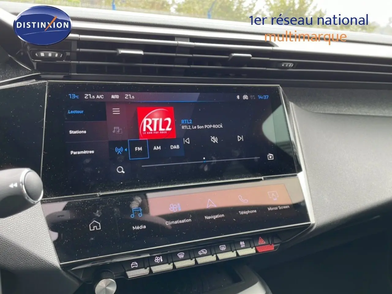 Vue rapprochée de l’écran tactile central du tableau de bord de la Peugeot 408 gris Selenium, affichant la radio RTL2.