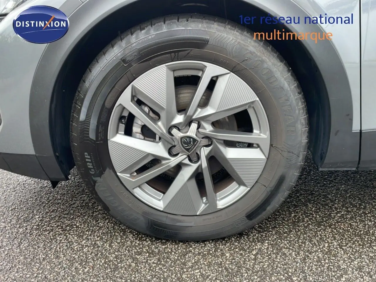 Gros plan sur la roue avant droite du Peugeot 408 gris selenium metal, mettant en valeur la jante design et le pneu Goodyear.