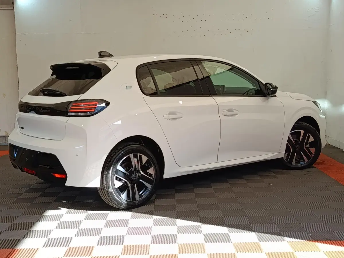 Peugeot 208 électrique blanche vue de profil droit, avec jantes noires et feux arrière LED distinctifs.