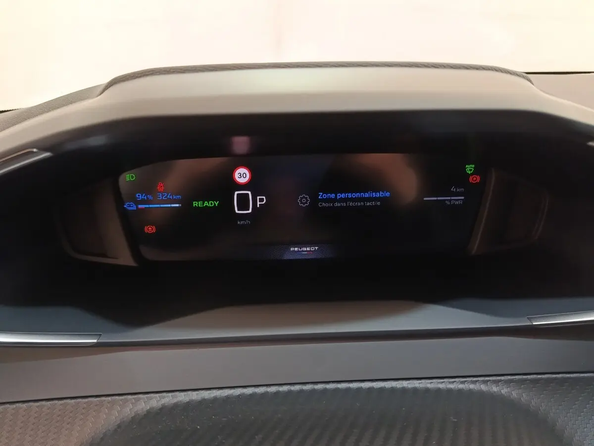 Tableau de bord numérique du Peugeot 208 électrique 2024, affichage multifonctions avec indication batterie et vitesse.