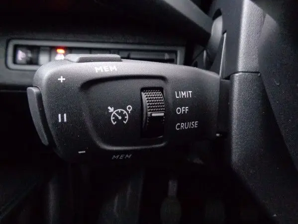 Gros plan sur la commande de régulateur de vitesse noire du Peugeot 3008 2023, version essence gris Artense Metal.