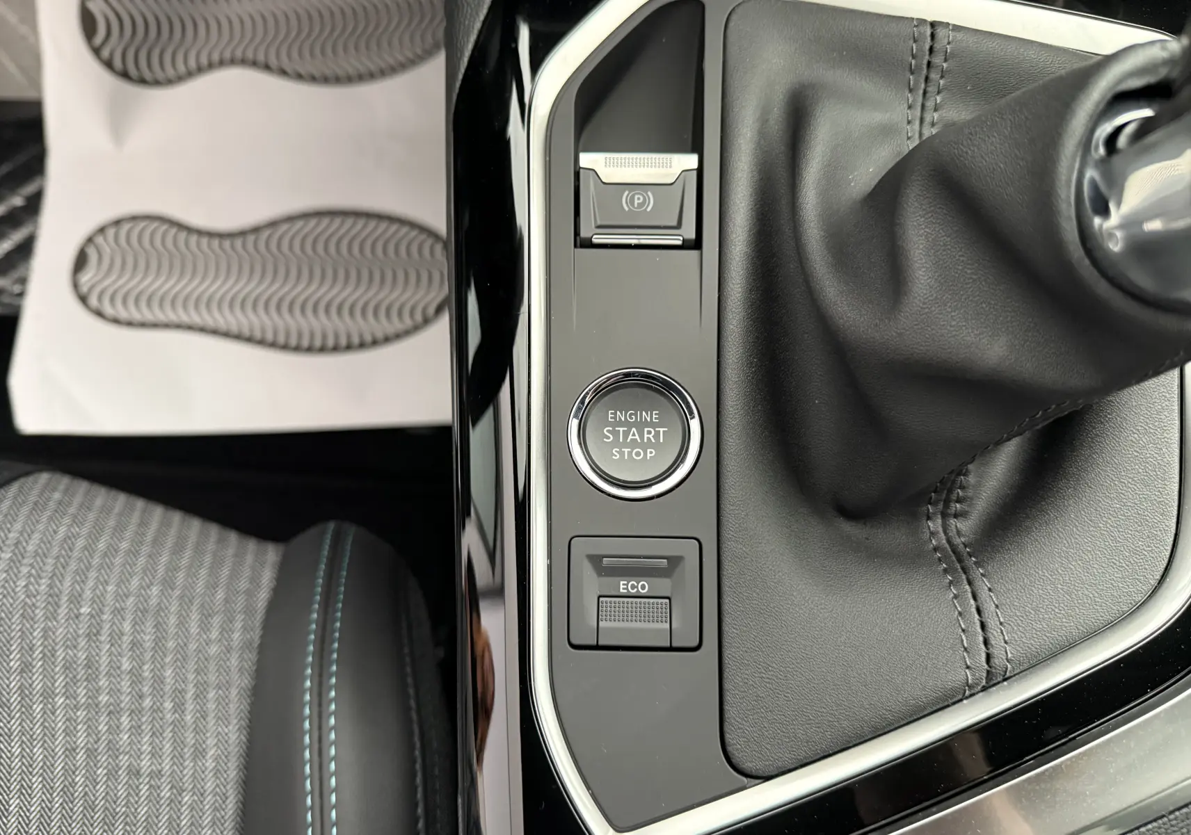 Vue rapprochée de la console centrale du Peugeot 3008 gris, montrant le levier de vitesse manuel et les boutons Start/Stop et mode Eco.