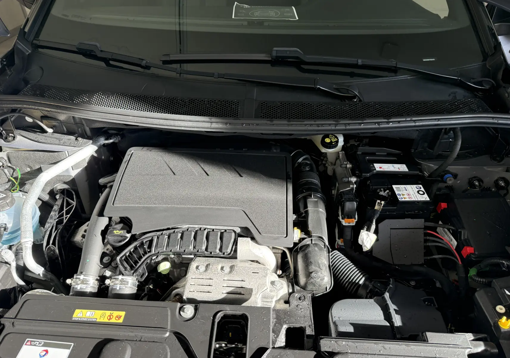 Moteur essence du Peugeot 3008 gris Artense Metal vu de dessus, montrant le compartiment moteur propre et organisé.