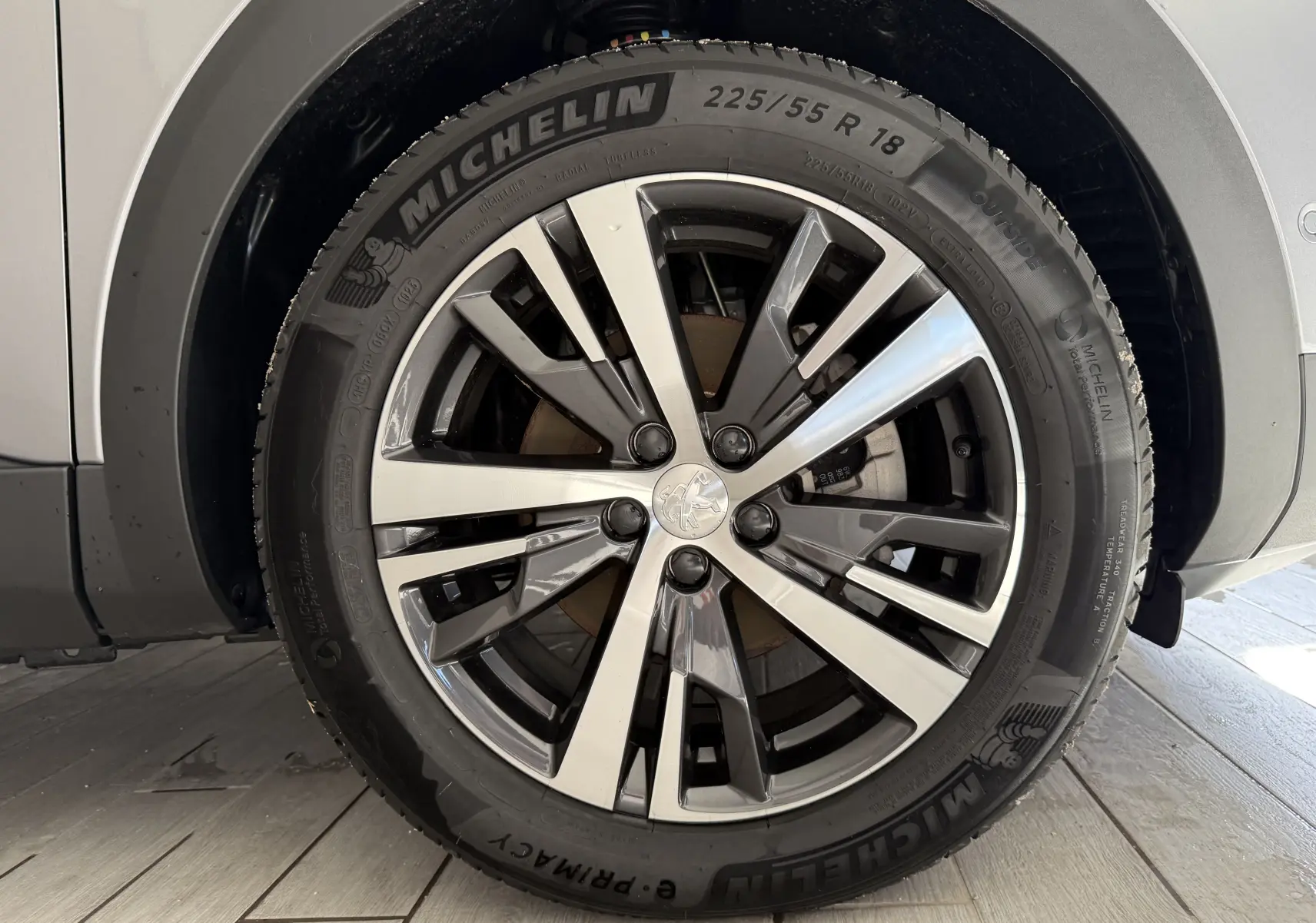Gros plan sur la roue avant droite du Peugeot 3008 gris Artense Métal avec jante alliage bicolore et pneu Michelin.