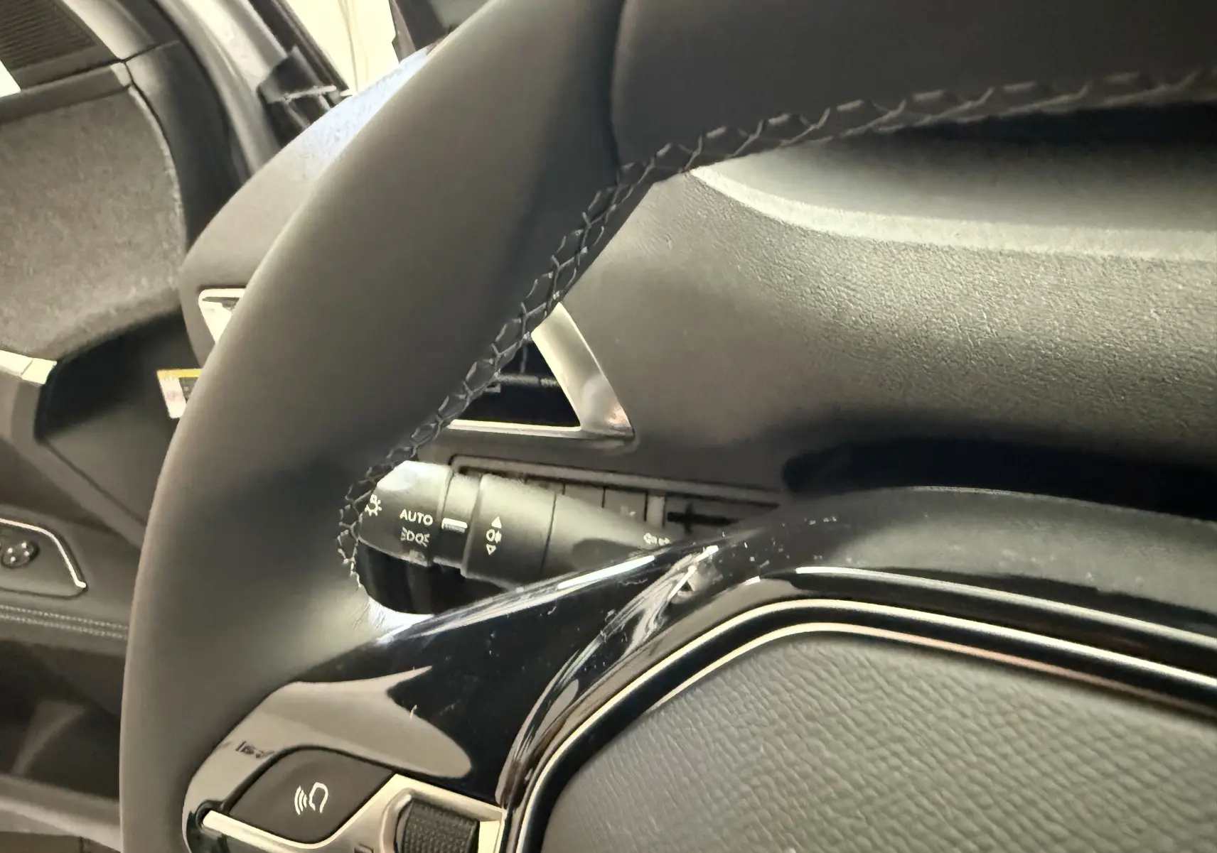Gros plan sur le volant en cuir noir et les commandes intégrées du Peugeot 3008 gris Artense Metal 2023.