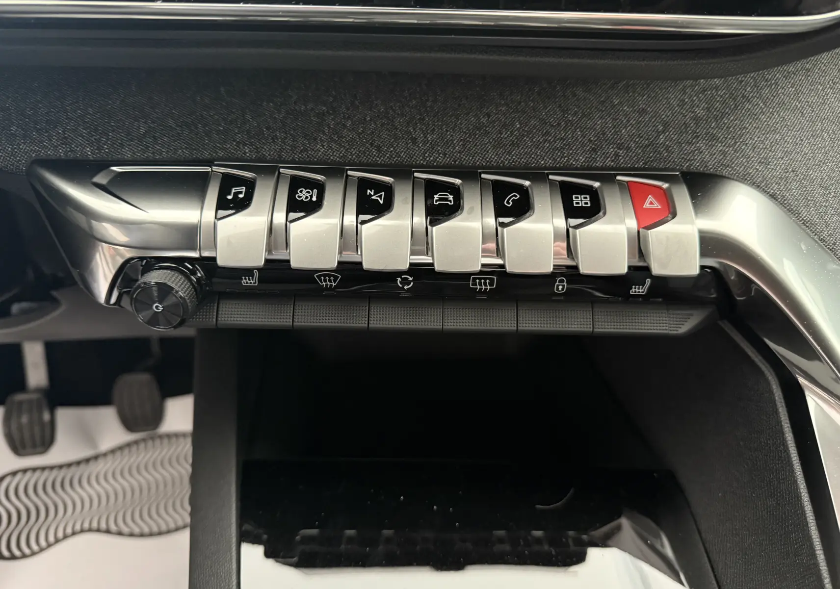 Vue rapprochée des commandes centrales en métal brossé du Peugeot 3008 gris Artense, avec boutons fonctionnels et alerte rouge.
