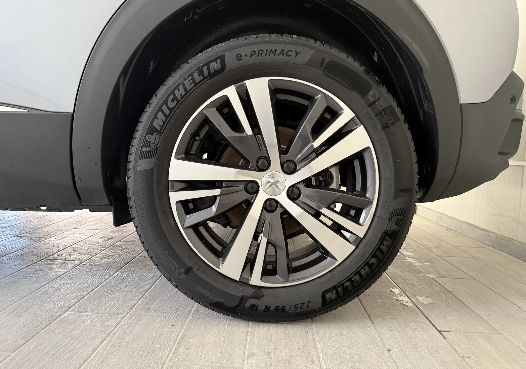 Gros plan sur la roue avant droite du Peugeot 3008 gris Artense, avec jante alliage et pneu Michelin e-Primacy.