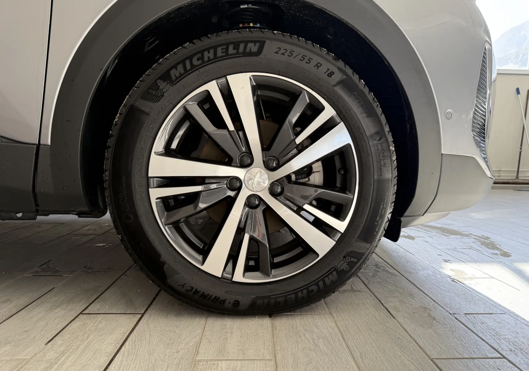 Gros plan sur la roue avant droite du Peugeot 3008 gris Artense métal avec jante alliage et pneu Michelin.