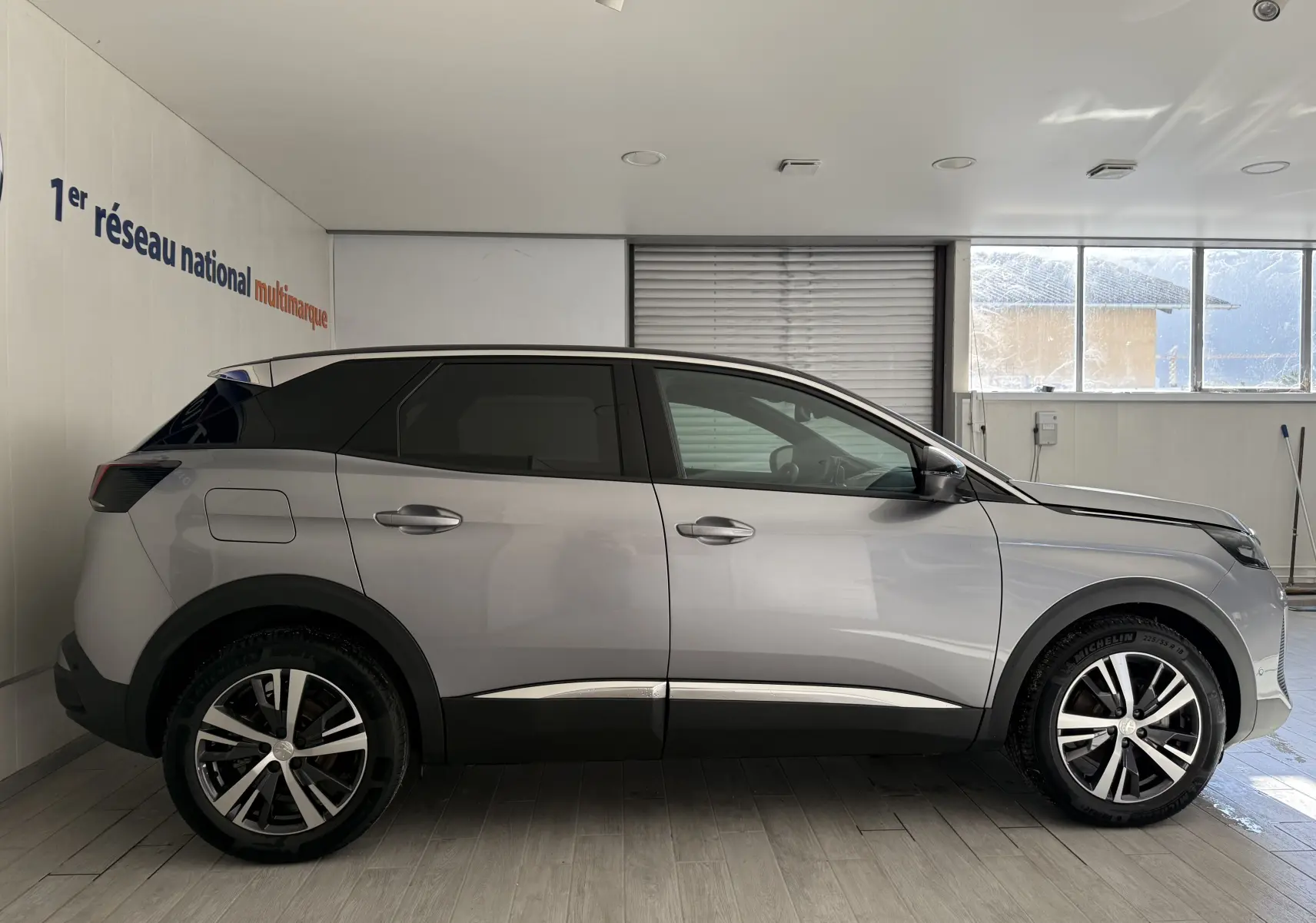 Profil côté gauche du Peugeot 3008 gris Artense Metal 2023, avec toit noir et jantes alliage bicolores.