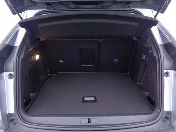 Coffre ouvert vu de l'arrière du Peugeot 3008 gris Artense Metal, espace de chargement spacieux et bien éclairé.