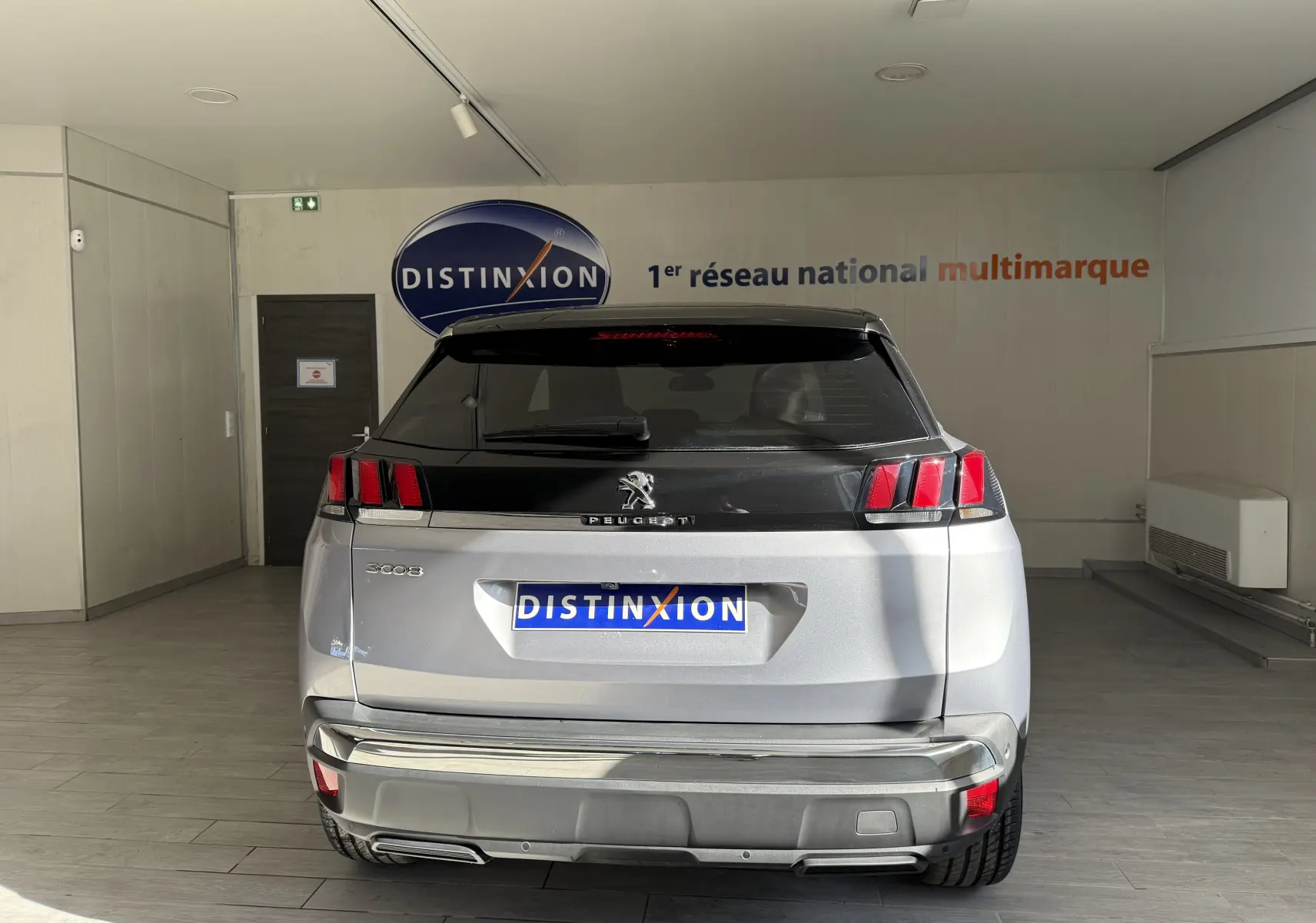 Vue arrière d'un Peugeot 3008 gris Artense métal avec toit noir et feux arrière à trois griffes rouges.