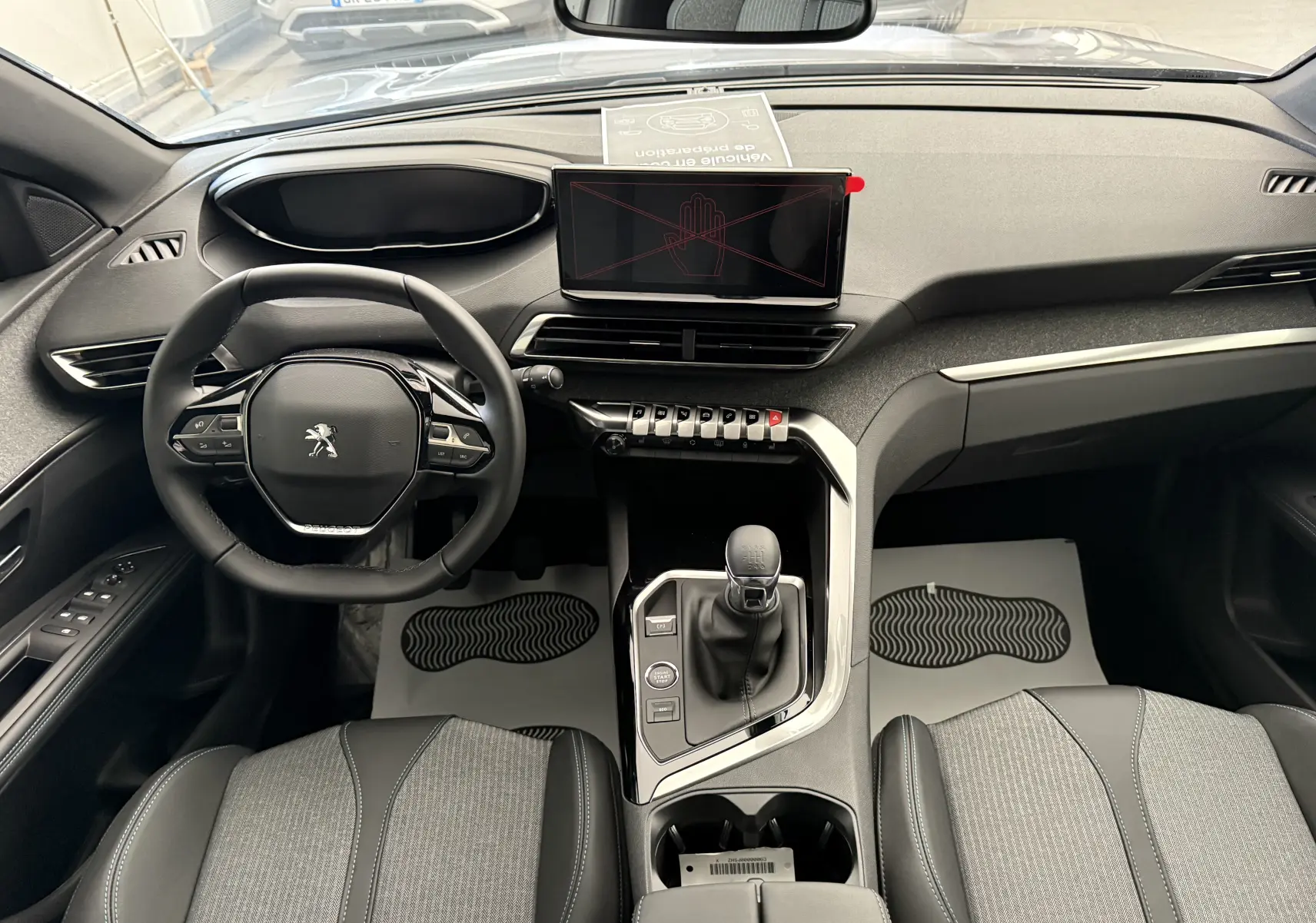 Vue intérieure frontale du Peugeot 3008 2023 avec tableau de bord moderne, volant compact et écran tactile central.