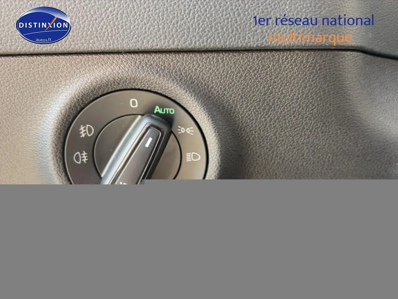 Gros plan sur la molette de réglage des phares dans l'habitacle gris du Skoda Karoq 2025.