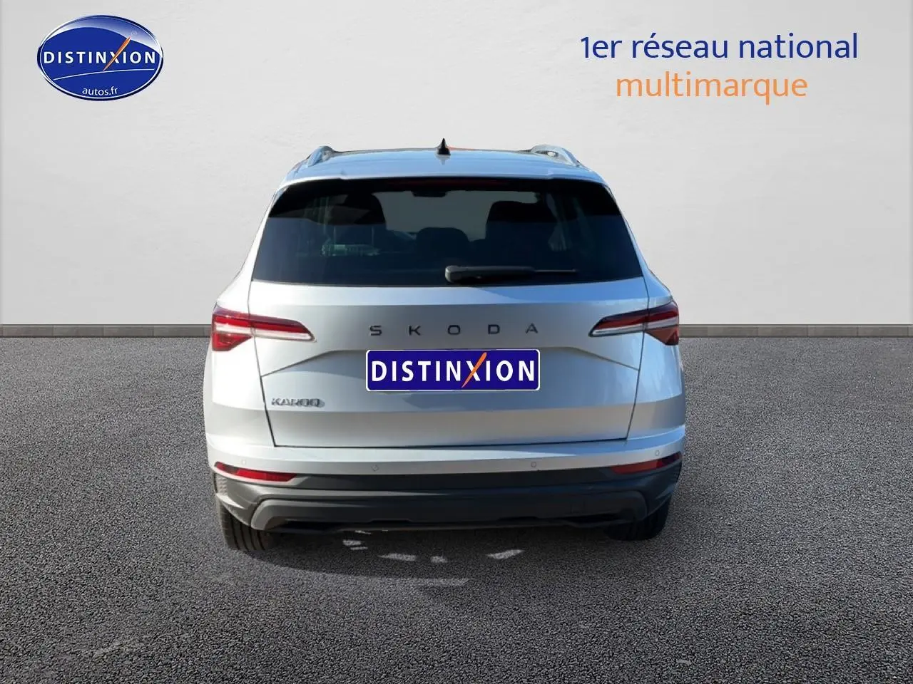 Vue arrière d'un Skoda Karoq gris 2025 avec feux arrière LED et barres de toit visibles.