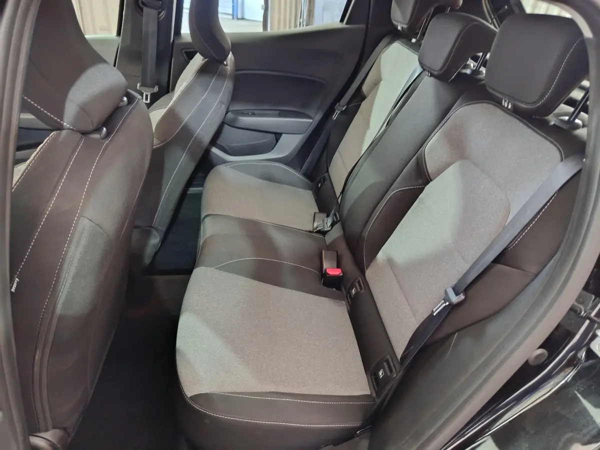 Vue intérieure côté droit des sièges arrière gris et noirs d'une Renault Clio noire, montrant les ceintures et appuie-têtes.