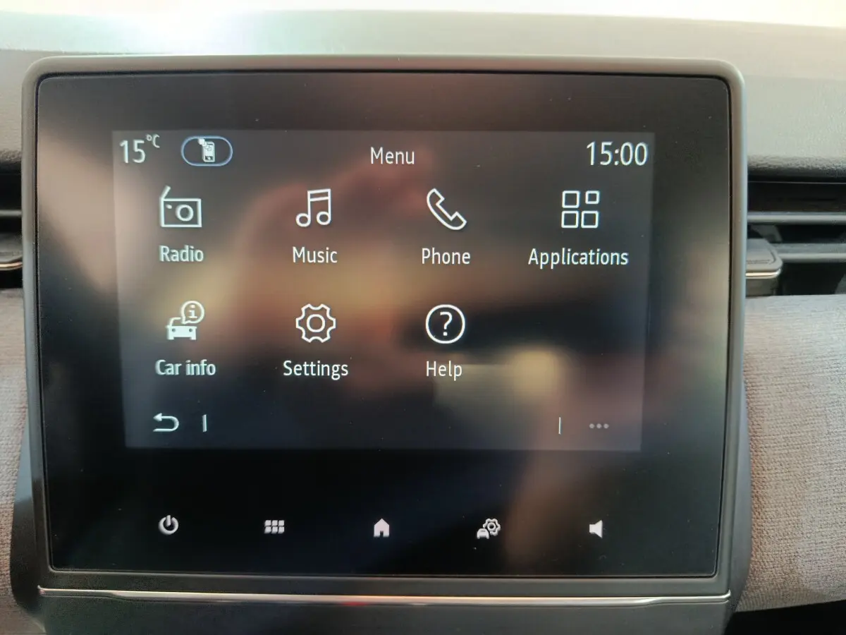 Écran tactile central de la Renault Clio noir affichant le menu principal avec icônes radio, musique, téléphone et applications.