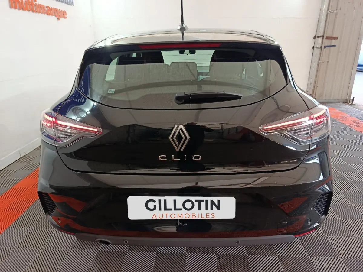 Vue arrière d'une Renault Clio noire 2025 avec feux LED allumés dans un garage.