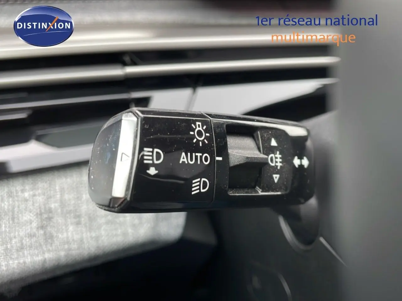 Gros plan sur la commande des phares du Peugeot 3008 gris Artense, montrant les réglages automatiques et feux antibrouillard.